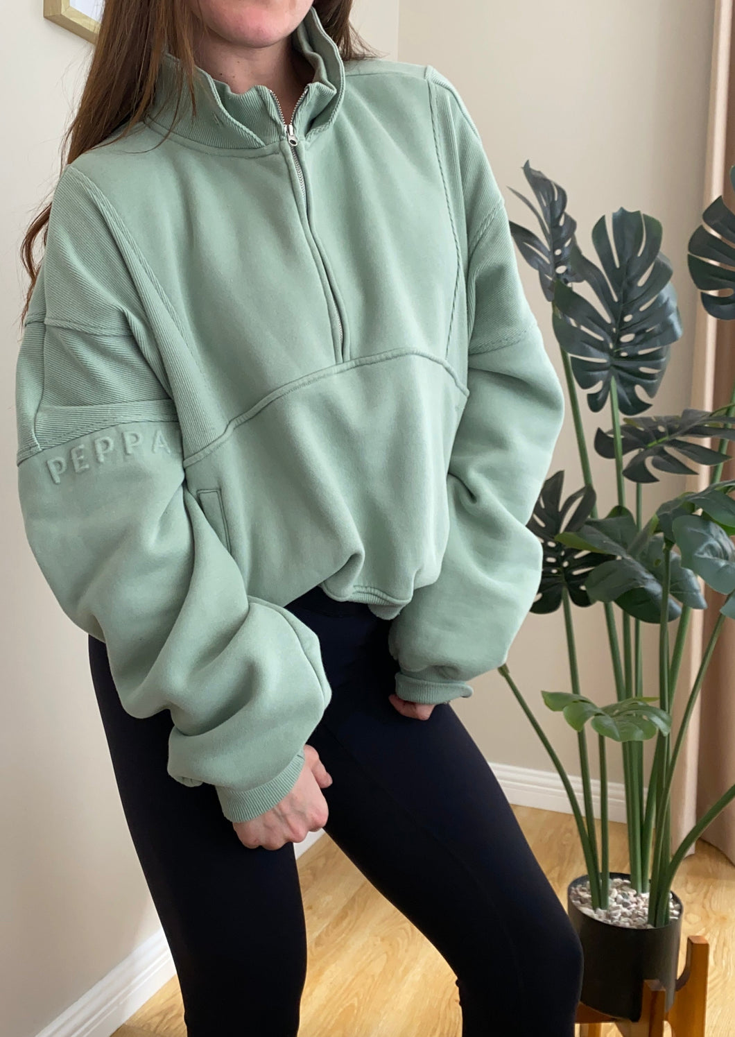 Fleece lined crop jacket in light green with half zip, and ribbed panels, and side pockets.