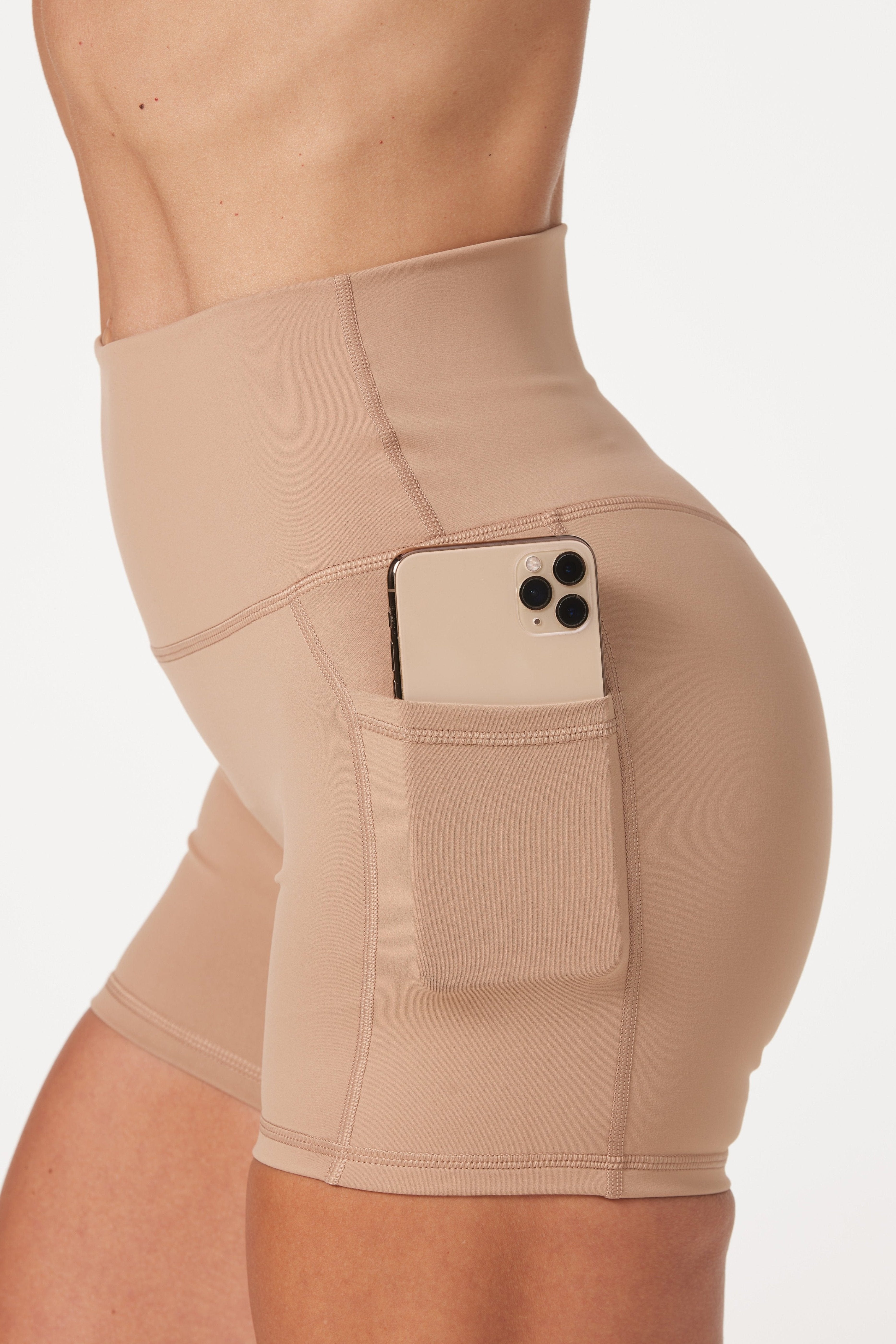high waisted 4" inseam activewear shorts with no front rise seam, in a buttery soft, supportive fabric in light taupe colour