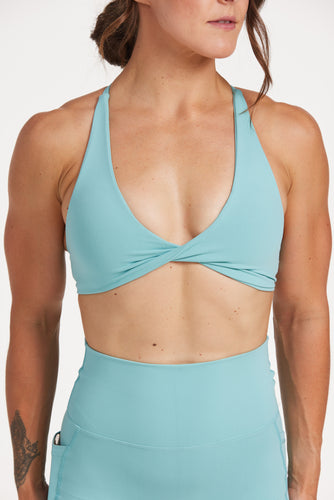 twist front bra with cross over back straps in a buttery soft fabric in a lagoon green