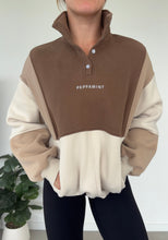 Load image into Gallery viewer, 1/4 button up fleece jumper with earthy colour panels in chocolate and beige, with feature panels ribbed stretchy fabric inserts, and two convenient zip pockets.
