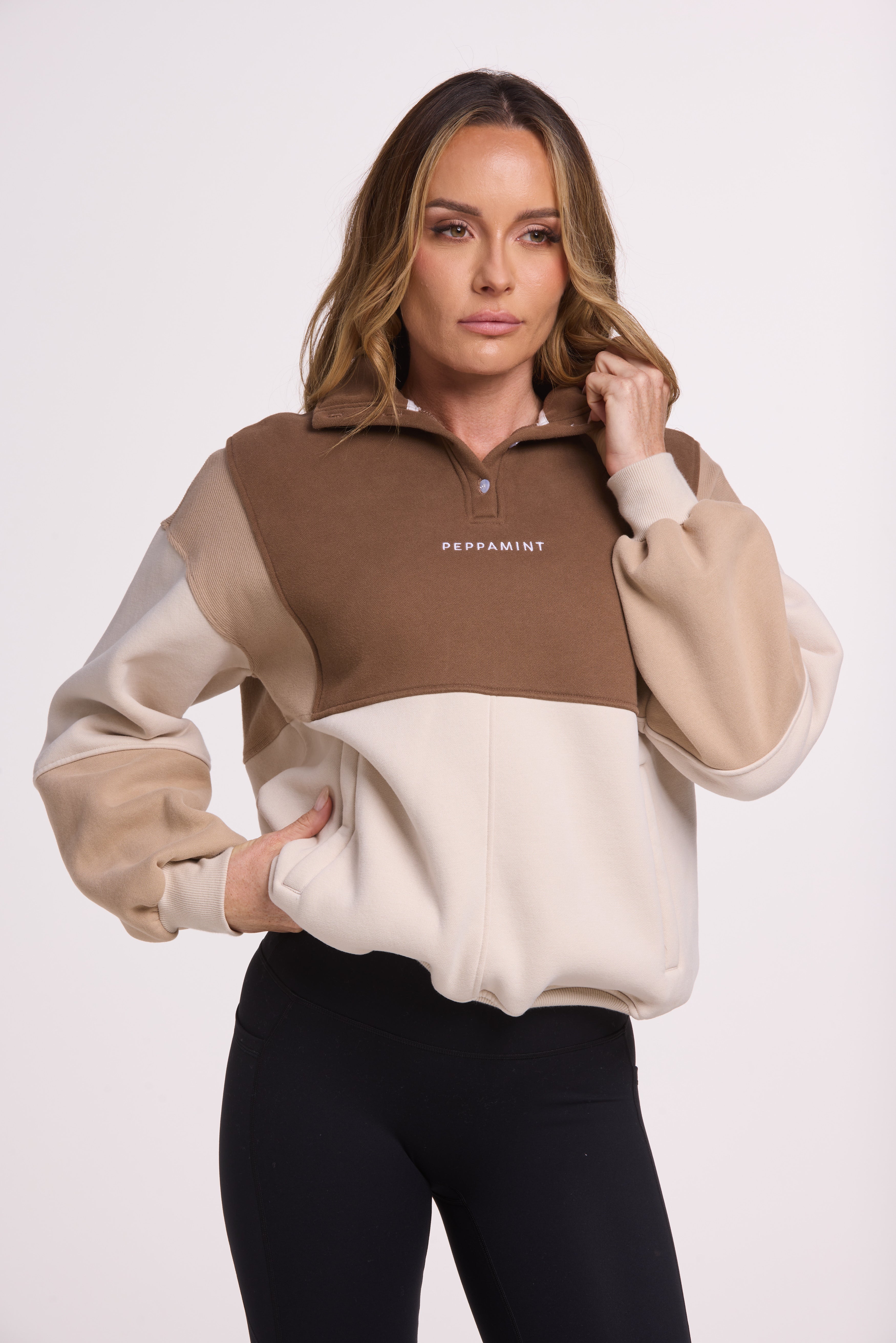 1/4 button up fleece jumper with earthy colour panels in chocolate and beige, with feature panels ribbed stretchy fabric inserts, and two convenient zip pockets.