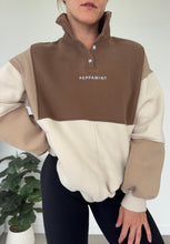 Load image into Gallery viewer, 1/4 button up fleece jumper with earthy colour panels in chocolate and beige, with feature panels ribbed stretchy fabric inserts, and two convenient zip pockets.

