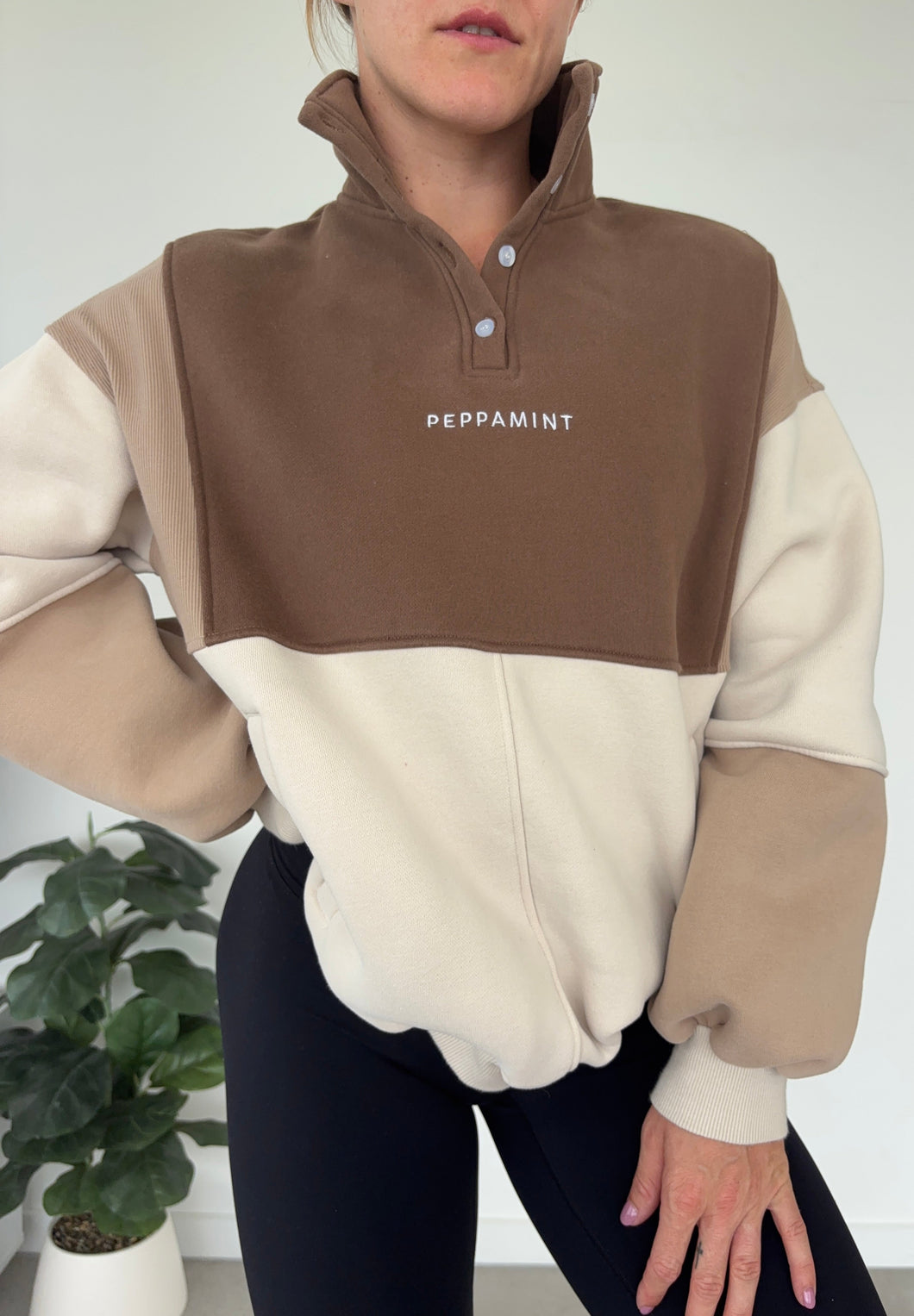 1/4 button up fleece jumper with earthy colour panels in chocolate and beige, with feature panels ribbed stretchy fabric inserts, and two convenient zip pockets.