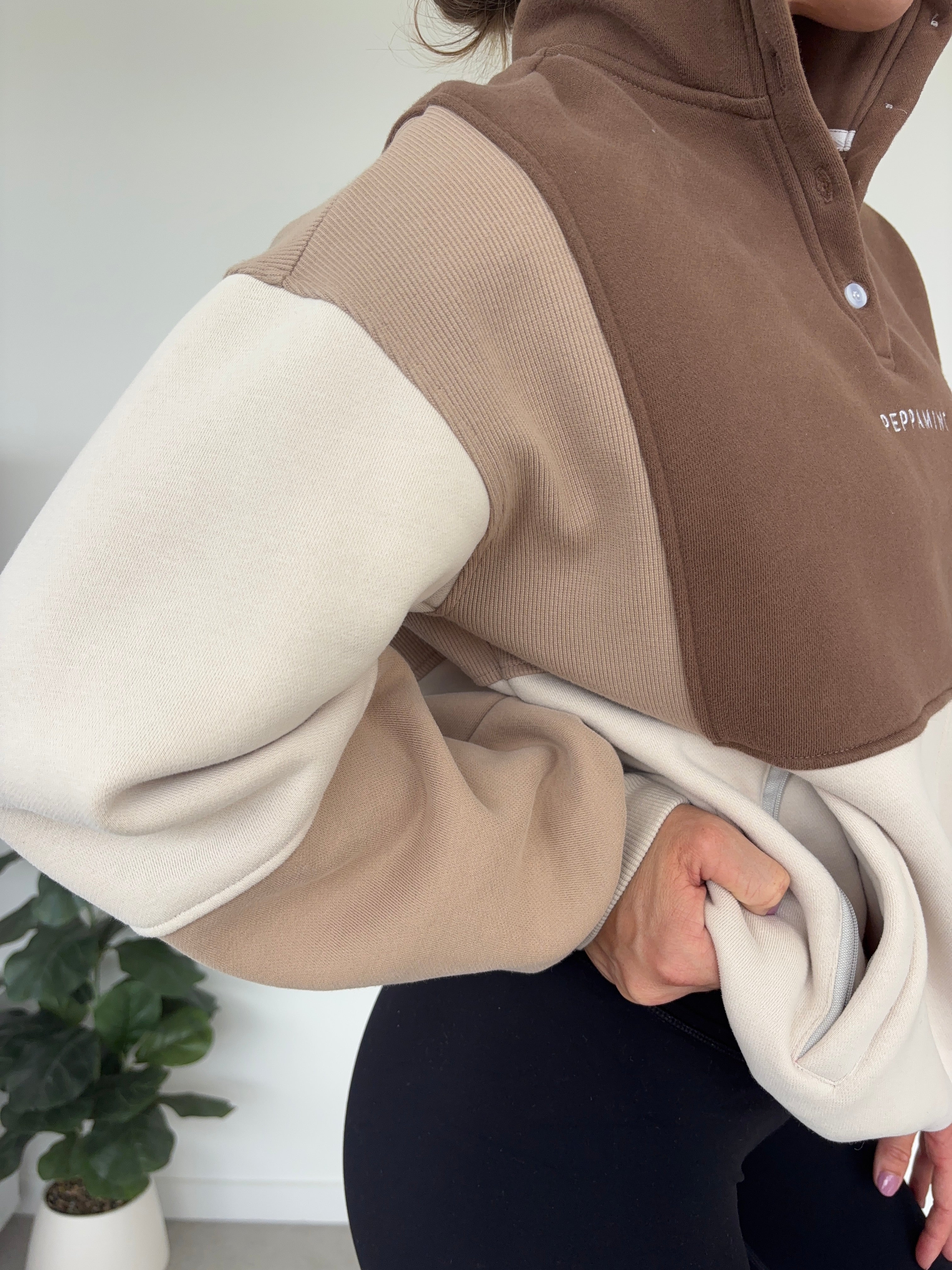 1/4 button up fleece jumper with earthy colour panels in chocolate and beige, with feature panels ribbed stretchy fabric inserts, and two convenient zip pockets.
