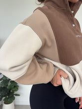 Load image into Gallery viewer, 1/4 button up fleece jumper with earthy colour panels in chocolate and beige, with feature panels ribbed stretchy fabric inserts, and two convenient zip pockets.

