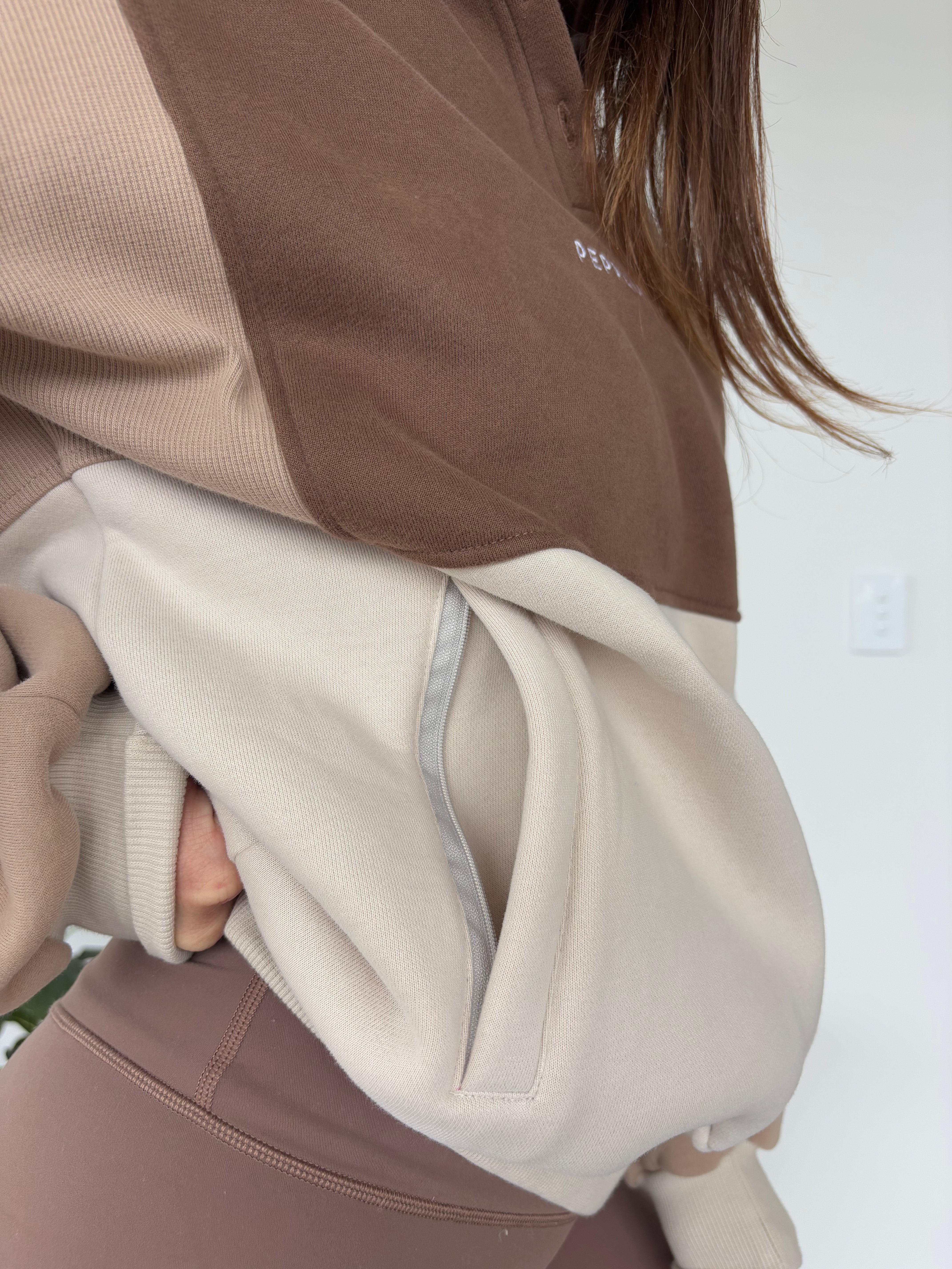 1/4 button up fleece jumper with earthy colour panels in chocolate and beige, with feature panels ribbed stretchy fabric inserts, and two convenient zip pockets.