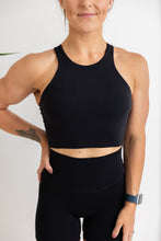 Load image into Gallery viewer, crop tank top in black with build in removable bra pads, racerback design and subtle stitched logo tag
