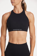 Load image into Gallery viewer, Buttery soft high waisted women&#39;s gym shorts with 4&quot; inseam with curved stitched detailing for a butt shaping effect, and no front rise seam, paired with a high neck women&#39;s sports bra with a supportive elasticated hem and triple layered fabric with removable pads for extra support and crossover back straps in Black.
