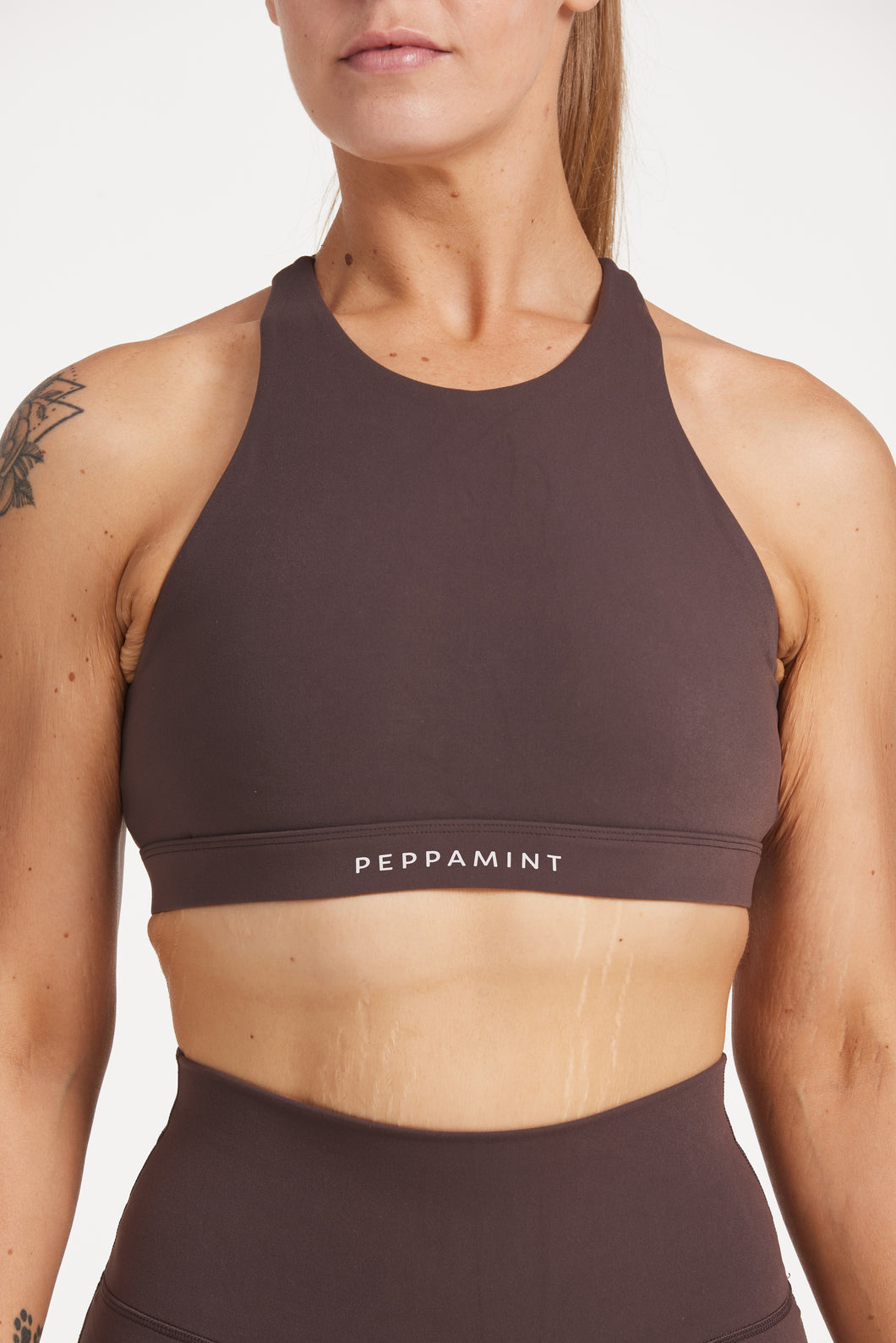 Buttery soft high neck women's sports bra with a supportive elasticated hem and triple layered fabric with removable pads for extra support and crossover back straps in Dark Chocolate.