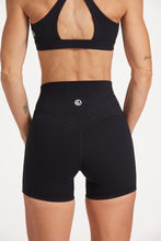 Load image into Gallery viewer, Buttery soft high waisted women&#39;s gym shorts with 4&quot; inseam with curved stitched detailing for a butt shaping effect, and no front rise seam, paired with a high neck women&#39;s sports bra with a supportive elasticated hem and triple layered fabric with removable pads for extra support and crossover back straps in Black.
