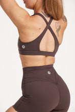 Load image into Gallery viewer, Buttery soft high waisted women&#39;s gym shorts with 4&quot; inseam with curved stitched detailing for a butt shaping effect, and no front rise seam, paired with a high neck women&#39;s sports bra with a supportive elasticated hem and triple layered fabric with removable pads for extra support and crossover back straps in Dark Chocolate.
