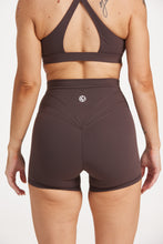 Load image into Gallery viewer, Buttery soft high waisted women&#39;s gym shorts with 4&quot; inseam with curved stitched detailing for a butt shaping effect, and no front rise seam, paired with a high neck women&#39;s sports bra with a supportive elasticated hem and triple layered fabric with removable pads for extra support and crossover back straps in Dark Chocolate.
