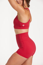 Load image into Gallery viewer, Buttery soft high waisted women&#39;s gym shorts with 4&quot; inseam with curved stitched detailing for a butt shaping effect, and no front rise seam, paired with a high neck women&#39;s sports bra with a supportive elasticated hem and triple layered fabric with removable pads for extra support and crossover back straps in Raspberry red.
