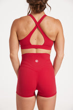 Load image into Gallery viewer, Buttery soft high waisted women&#39;s gym shorts with 4&quot; inseam with curved stitched detailing for a butt shaping effect, and no front rise seam, paired with a high neck women&#39;s sports bra with a supportive elasticated hem and triple layered fabric with removable pads for extra support and crossover back straps in Raspberry red.
