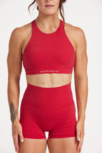 Load image into Gallery viewer, Buttery soft high waisted women&#39;s gym shorts with 4&quot; inseam with curved stitched detailing for a butt shaping effect, and no front rise seam, paired with a high neck women&#39;s sports bra with a supportive elasticated hem and triple layered fabric with removable pads for extra support and crossover back straps in Raspberry red.
