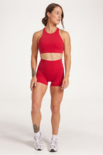 Load image into Gallery viewer, Buttery soft high waisted women&#39;s gym shorts with 4&quot; inseam with curved stitched detailing for a butt shaping effect, and no front rise seam, paired with a high neck women&#39;s sports bra with a supportive elasticated hem and triple layered fabric with removable pads for extra support and crossover back straps in Raspberry red.
