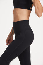 Load image into Gallery viewer, Buttery soft high waisted women&#39;s gym tights with curved hem stitched detailing for a butt shaping effect, and no front rise seam, paired with an open back women&#39;s crop t-shirt with a supportive elasticated hem and triple layered fabric with removable pads for extra support and aesthetic cross back straps in Black.
