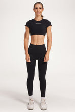 Load image into Gallery viewer, Buttery soft high waisted women&#39;s gym tights with curved hem stitched detailing for a butt shaping effect, and no front rise seam, paired with an open back women&#39;s crop t-shirt with a supportive elasticated hem and triple layered fabric with removable pads for extra support and aesthetic cross back straps in Black.
