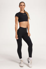 Load image into Gallery viewer, Buttery soft high waisted women&#39;s gym tights with curved hem stitched detailing for a butt shaping effect, and no front rise seam, paired with an open back women&#39;s crop t-shirt with a supportive elasticated hem and triple layered fabric with removable pads for extra support and aesthetic cross back straps in Black.
