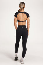 Load image into Gallery viewer, Buttery soft high waisted women&#39;s gym tights with curved hem stitched detailing for a butt shaping effect, and no front rise seam, paired with an open back women&#39;s crop t-shirt with a supportive elasticated hem and triple layered fabric with removable pads for extra support and aesthetic cross back straps in Black.
