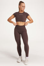 Load image into Gallery viewer, Buttery soft high waisted women&#39;s gym tights with curved hem stitched detailing for a butt shaping effect, and no front rise seam, paired with an open back women&#39;s crop t-shirt with a supportive elasticated hem and triple layered fabric with removable pads for extra support and aesthetic cross back straps in dark chocolate.
