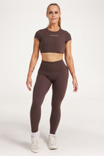 Load image into Gallery viewer, Buttery soft high waisted women&#39;s gym tights with curved hem stitched detailing for a butt shaping effect, and no front rise seam, paired with an open back women&#39;s crop t-shirt with a supportive elasticated hem and triple layered fabric with removable pads for extra support and aesthetic cross back straps in dark chocolate.
