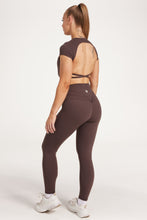 Load image into Gallery viewer, Buttery soft high waisted women&#39;s gym tights with curved hem stitched detailing for a butt shaping effect, and no front rise seam, paired with an open back women&#39;s crop t-shirt with a supportive elasticated hem and triple layered fabric with removable pads for extra support and aesthetic cross back straps in dark chocolate.
