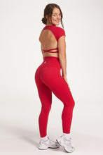 Load image into Gallery viewer, Buttery soft high waisted women&#39;s gym tights with curved hem stitched detailing for a butt shaping effect, and no front rise seam, paired with an open back women&#39;s crop t-shirt with a supportive elasticated hem and triple layered fabric with removable pads for extra support and aesthetic cross back straps in Raspberry red.
