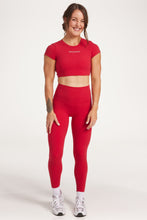 Load image into Gallery viewer, Buttery soft high waisted women&#39;s gym tights with curved hem stitched detailing for a butt shaping effect, and no front rise seam, paired with an open back women&#39;s crop t-shirt with a supportive elasticated hem and triple layered fabric with removable pads for extra support and aesthetic cross back straps in Raspberry red.
