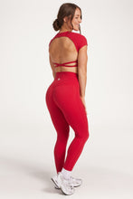 Load image into Gallery viewer, Buttery soft high waisted women&#39;s gym tights with curved hem stitched detailing for a butt shaping effect, and no front rise seam, paired with an open back women&#39;s crop t-shirt with a supportive elasticated hem and triple layered fabric with removable pads for extra support and aesthetic cross back straps in Raspberry red.
