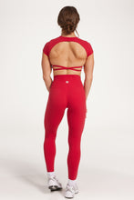 Load image into Gallery viewer, Buttery soft high waisted women&#39;s gym tights with curved hem stitched detailing for a butt shaping effect, and no front rise seam, paired with an open back women&#39;s crop t-shirt with a supportive elasticated hem and triple layered fabric with removable pads for extra support and aesthetic cross back straps in Raspberry red.
