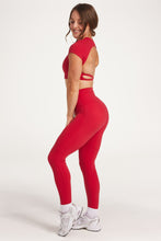 Load image into Gallery viewer, Buttery soft high waisted women&#39;s gym tights with curved hem stitched detailing for a butt shaping effect, and no front rise seam, paired with an open back women&#39;s crop t-shirt with a supportive elasticated hem and triple layered fabric with removable pads for extra support and aesthetic cross back straps in Raspberry red.
