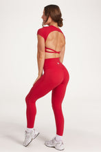 Load image into Gallery viewer, Buttery soft high waisted women&#39;s gym tights with curved hem stitched detailing for a butt shaping effect, and no front rise seam, paired with an open back women&#39;s crop t-shirt with a supportive elasticated hem and triple layered fabric with removable pads for extra support and aesthetic cross back straps in Raspberry red.
