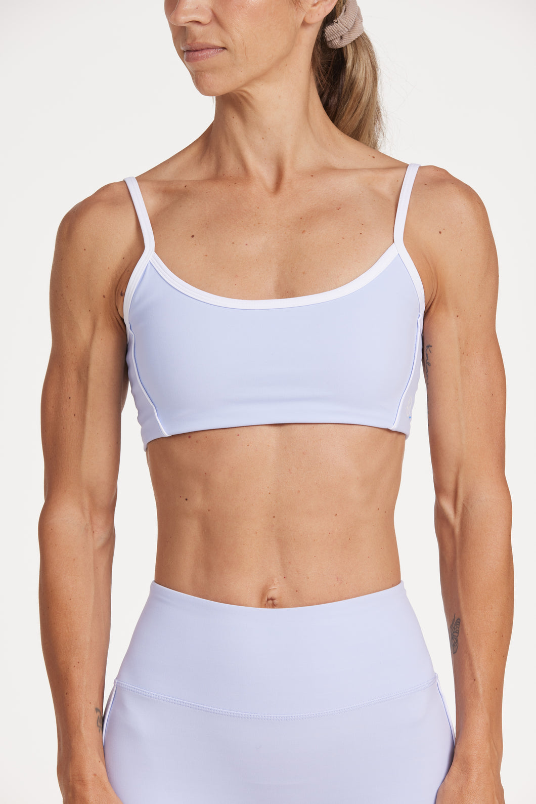 Womens scoops neck sports bra complete with white trim, elasticated hem, and supportive thick backstraps in periwinkle blue