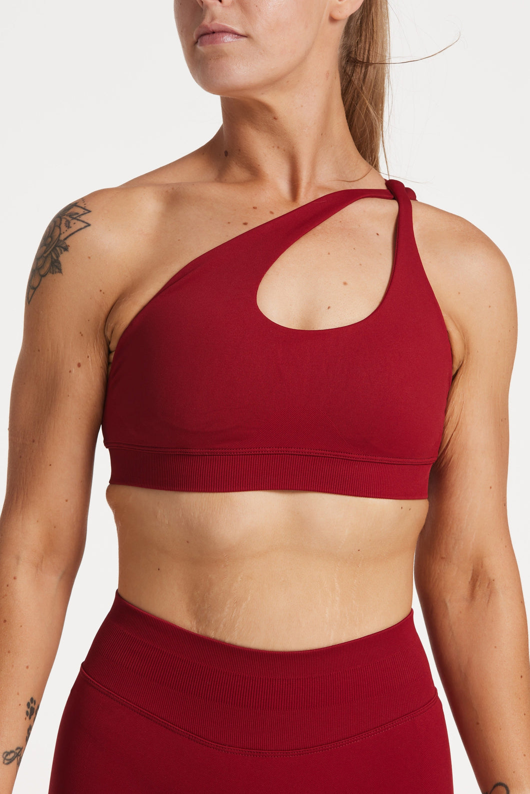 Cross over strap activewear bra in seamless fabric with adjustable back straps, and ribbed supportive underbust band in wine red