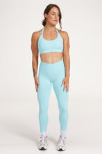 Load image into Gallery viewer, seamless gym tights with booty contouring effect, sweetheart butt seams and thick supportive fabric in ice blue and seamless halter bra with a thick supportive fabric blend and a branded back strap in ice blue
