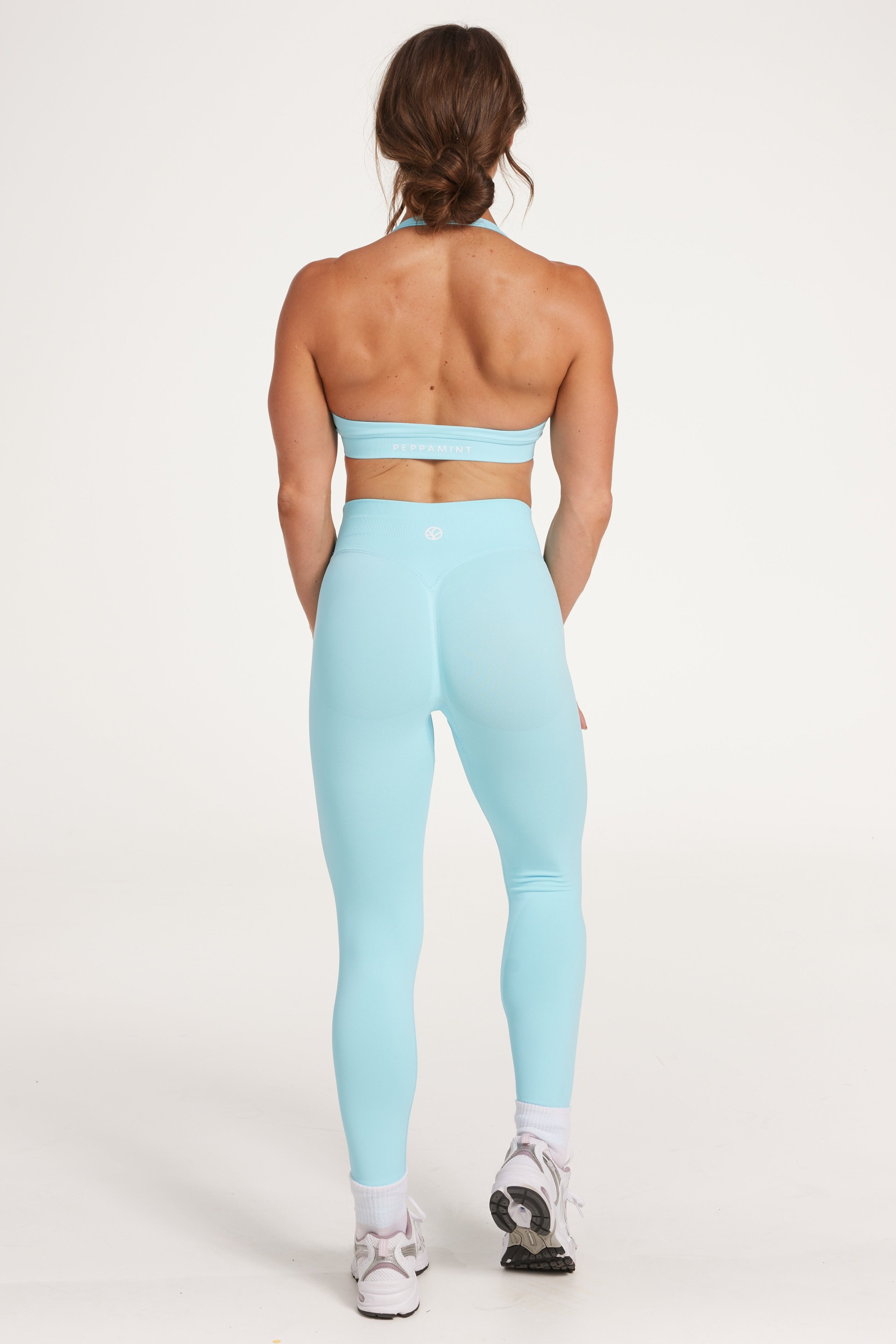 seamless gym tights with booty contouring effect, sweetheart butt seams and thick supportive fabric in ice blue and seamless halter bra with a thick supportive fabric blend and a branded back strap in ice blue