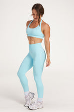 Load image into Gallery viewer, seamless gym tights with booty contouring effect, sweetheart butt seams and thick supportive fabric in ice blue and seamless halter bra with a thick supportive fabric blend and a branded back strap in ice blue
