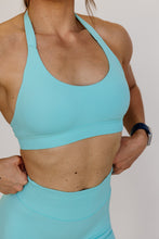 Load image into Gallery viewer, seamless halter bra with a thick supportive fabric blend and a branded back strap in mint green
