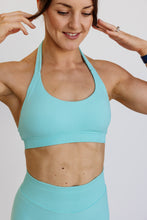 Load image into Gallery viewer, seamless halter bra with a thick supportive fabric blend and a branded back strap in mint green
