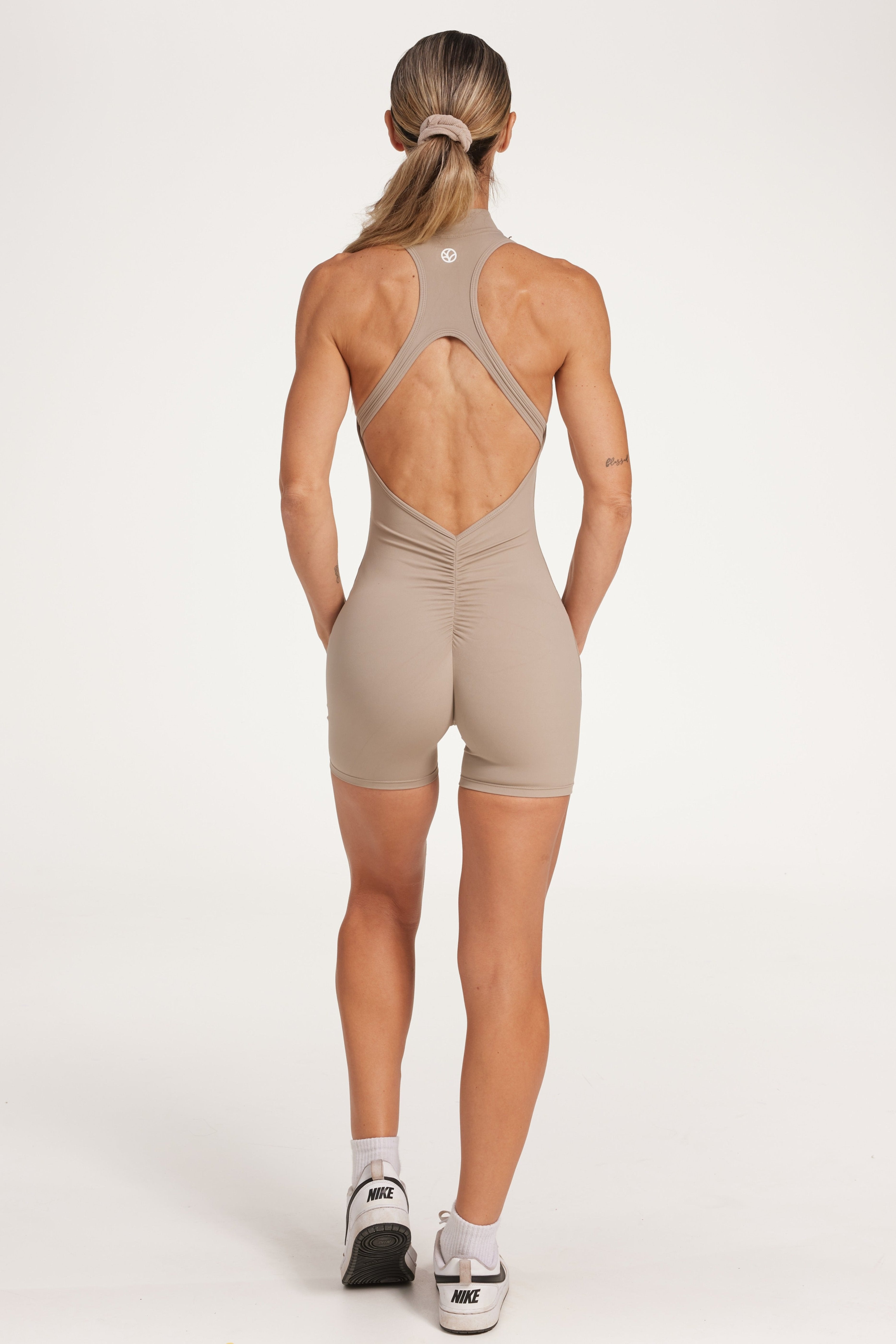 High neck bodysuit with half zipper, scrunch bum detailing, in short length made from a buttery soft flexible fabric in pumice stone