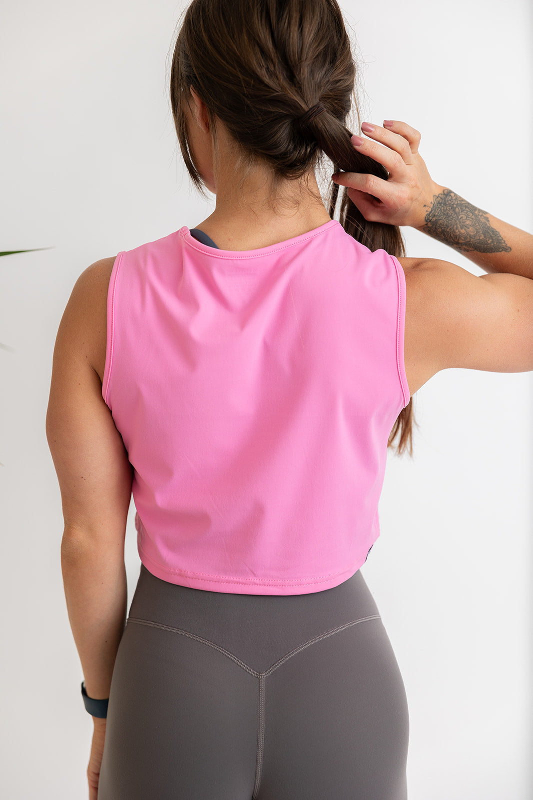 buttery soft crop length tank top in baby pink with subtle stitched logo tag