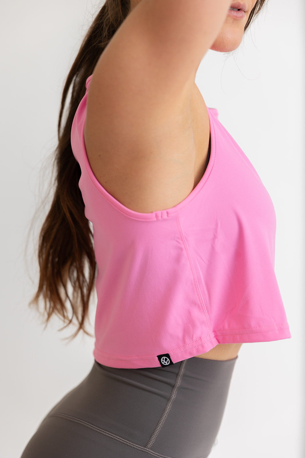 buttery soft crop length tank top in baby pink with subtle stitched logo tag