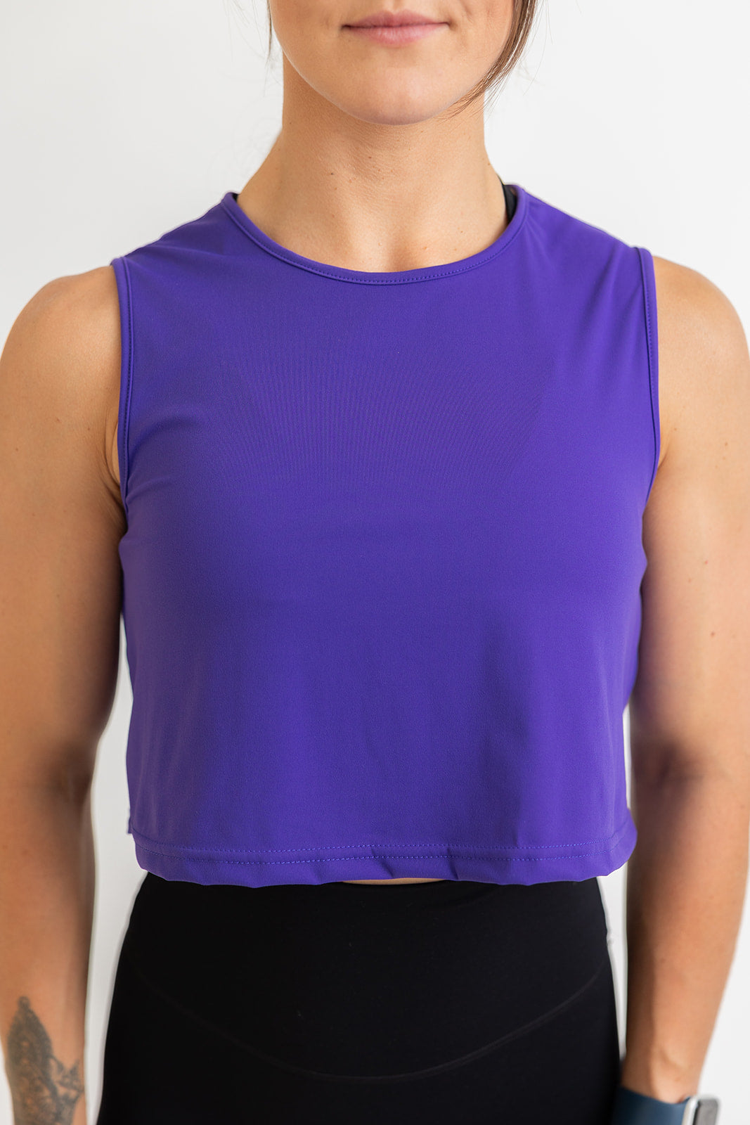 buttery soft crop length tank top in purple blue with subtle stitched logo tag