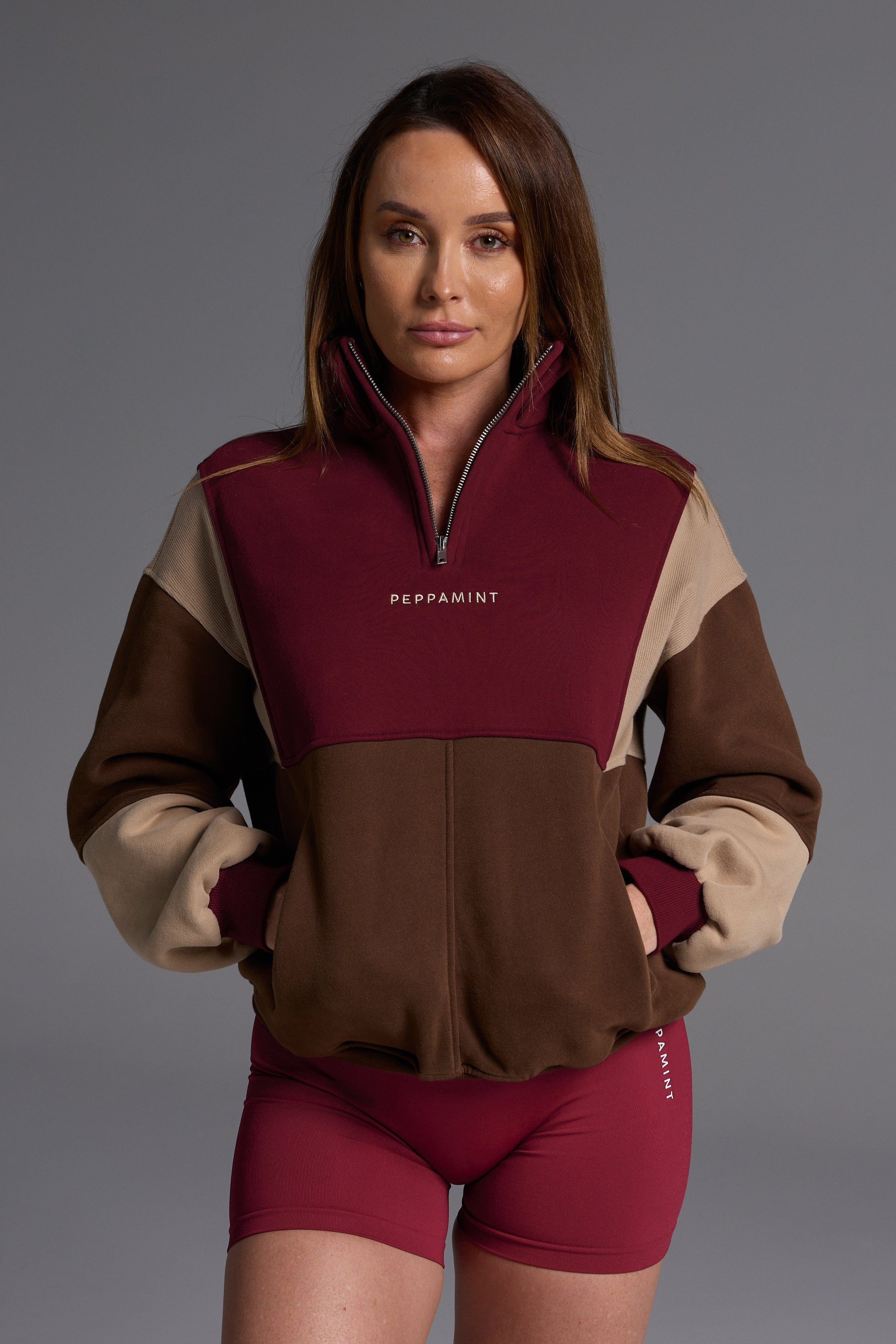 1/4 zip fleece jumper with double collar, ribbed stretchy fabric panel inserts, and two convenient zip pockets in a wine, chocolate and beige colour block design.