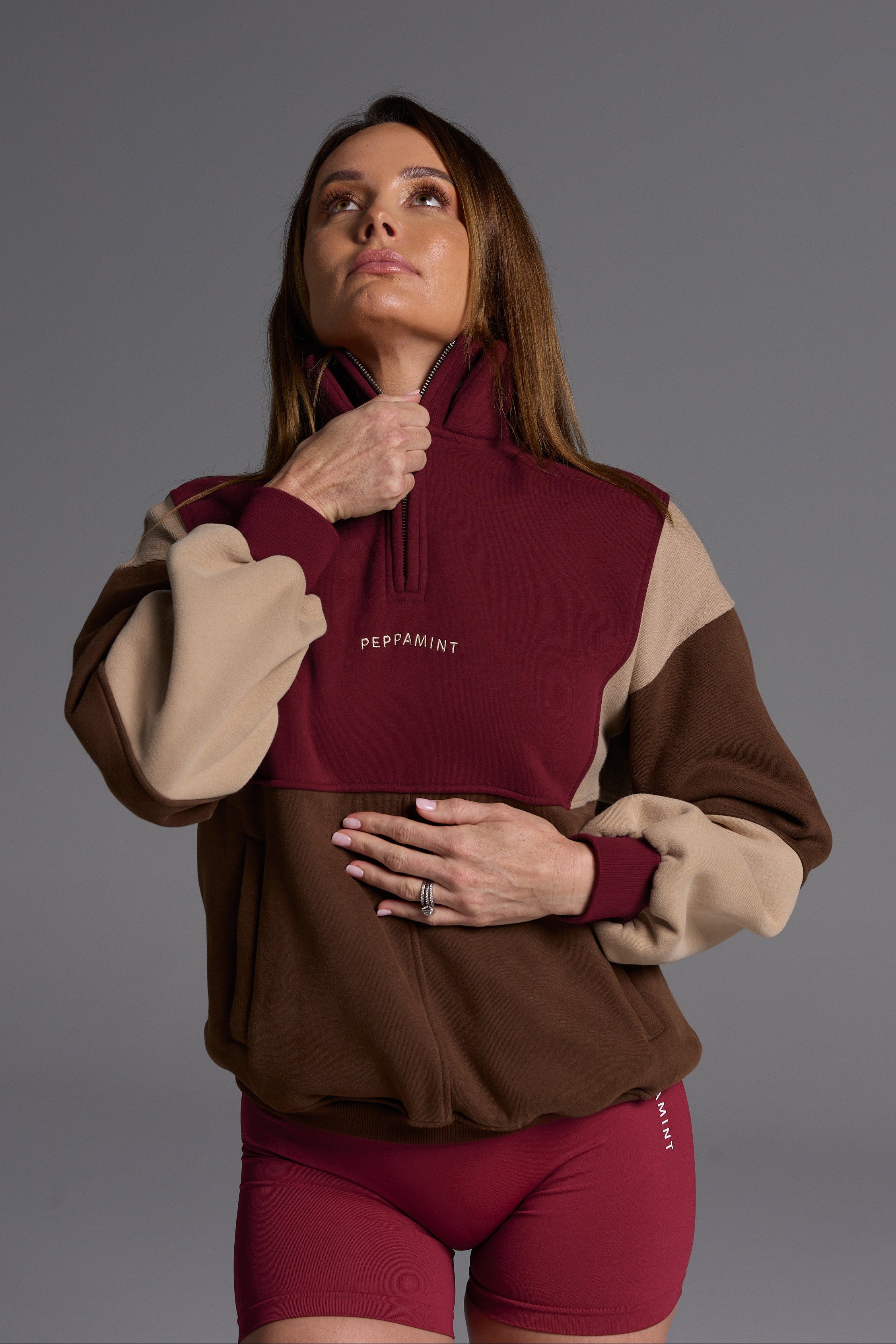 1/4 zip fleece jumper with double collar, ribbed stretchy fabric panel inserts, and two convenient zip pockets in a wine, chocolate and beige colour block design.