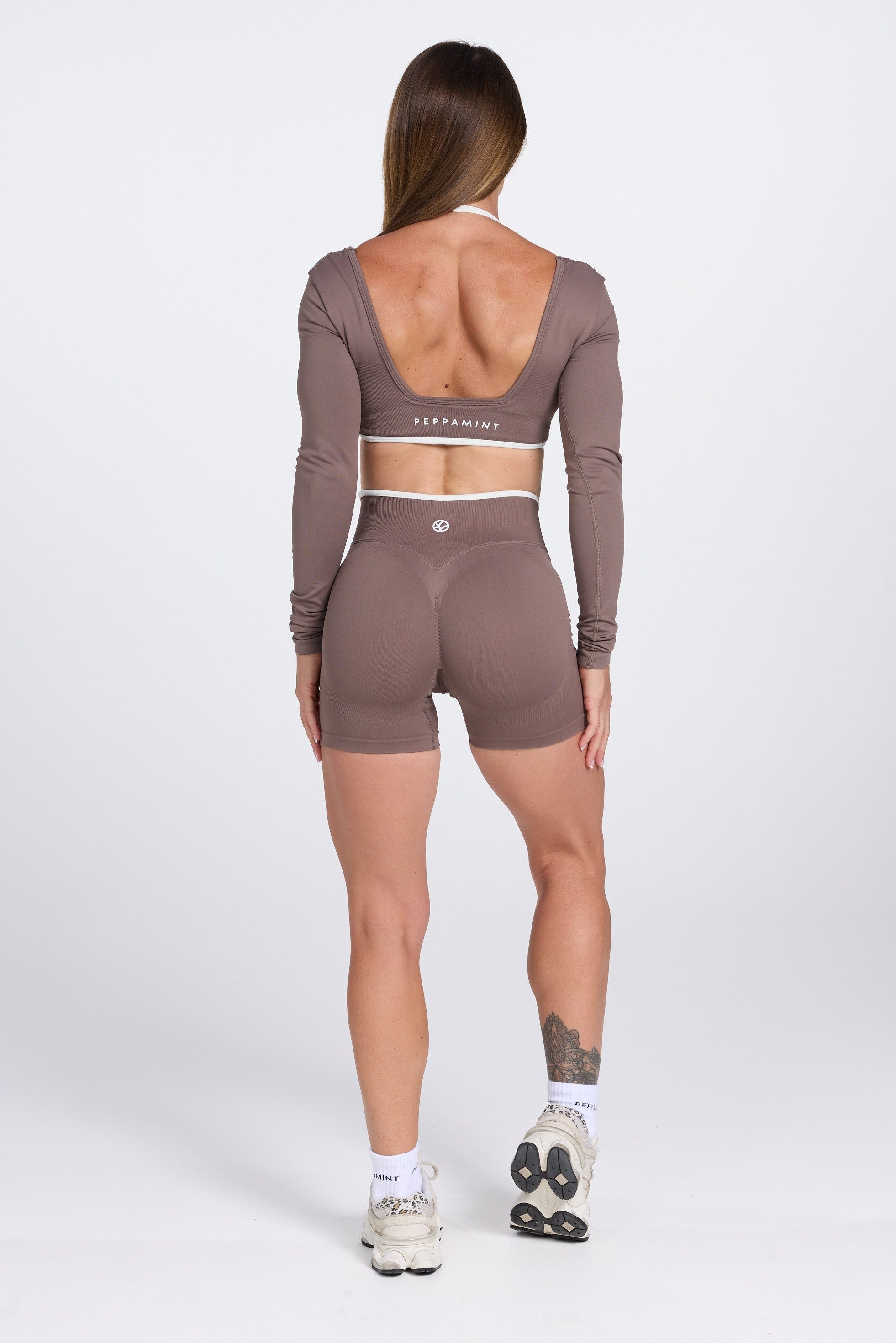 Long sleeve seamless crop top, with built in white contrasting bra, luxe white trim, and adjustable halter strap, with high waisted booty sculpting gym shorts in Mocha.