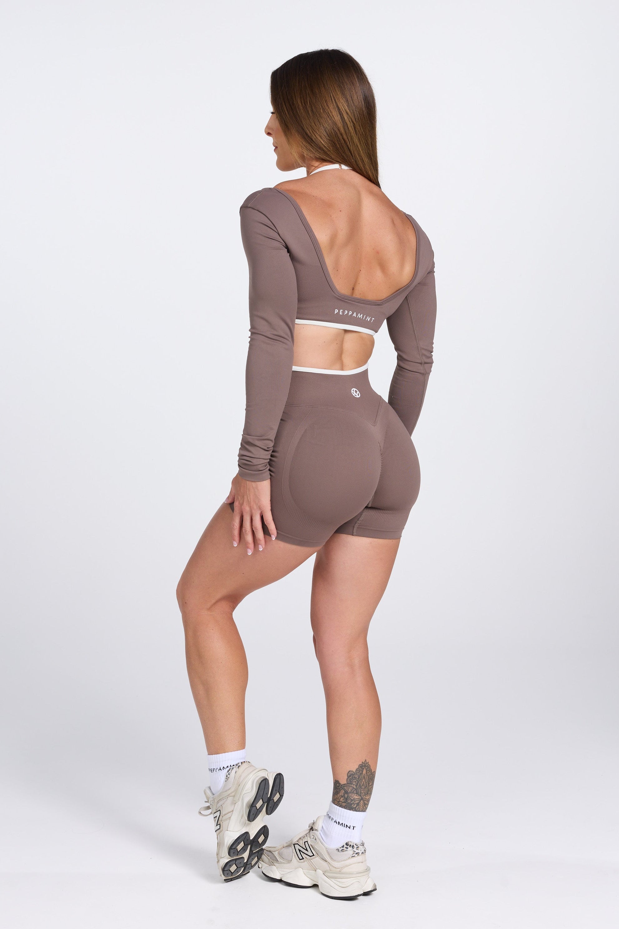 Long sleeve seamless crop top, with built in white contrasting bra, luxe white trim, and adjustable halter strap, with high waisted booty sculpting gym shorts in Mocha.