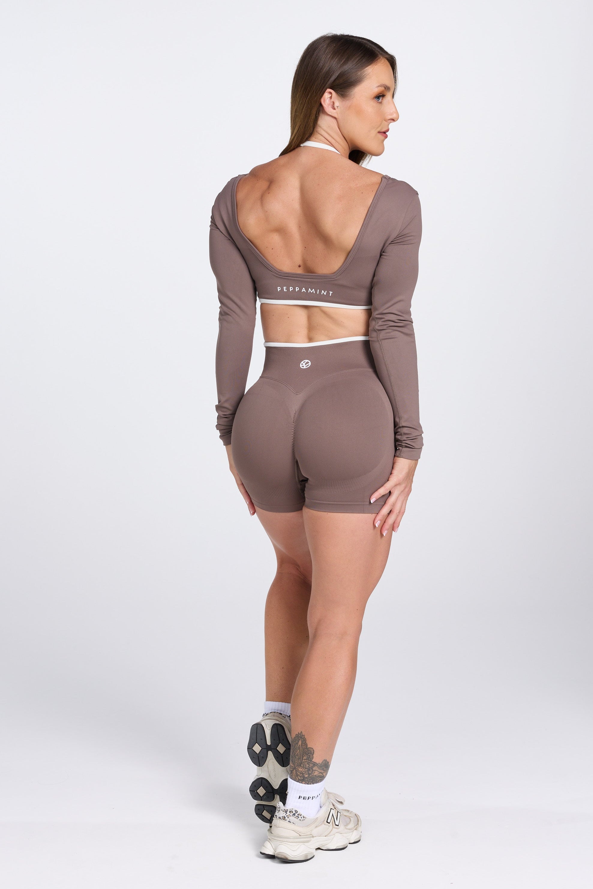 Long sleeve seamless crop top, with built in white contrasting bra, luxe white trim, and adjustable halter strap, with high waisted booty sculpting gym shorts in Mocha.