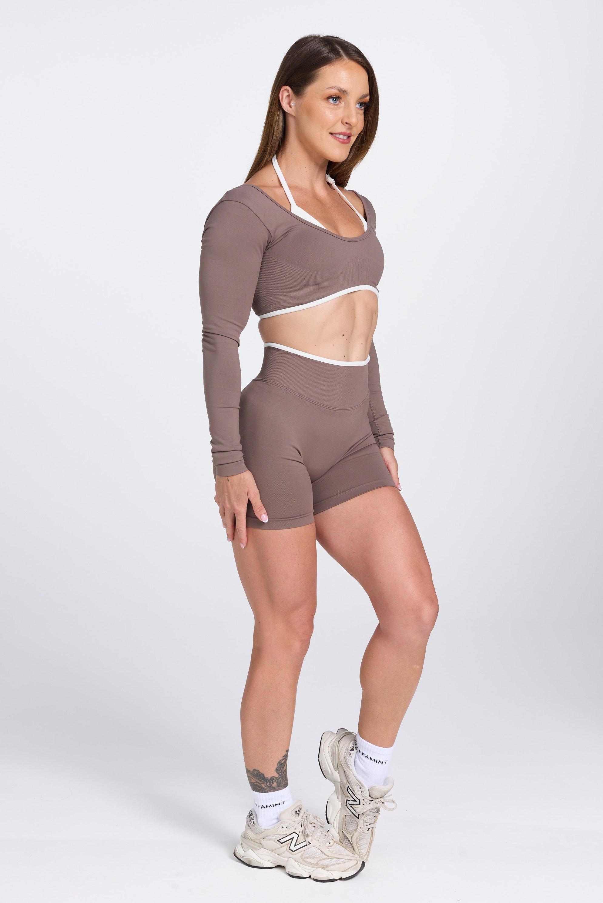 Long sleeve seamless crop top, with built in white contrasting bra, luxe white trim, and adjustable halter strap, with high waisted booty sculpting gym shorts in Mocha.